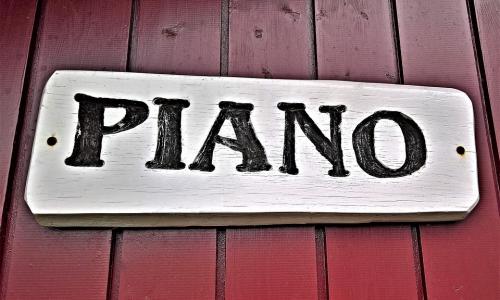 Piano, insegna in legno